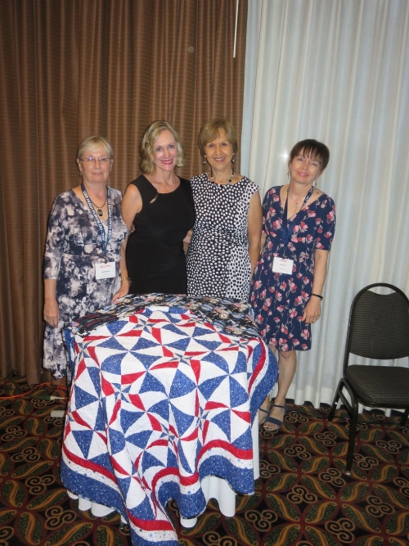 4 Ladies display the quilt they are selling the 50-50 tickets for